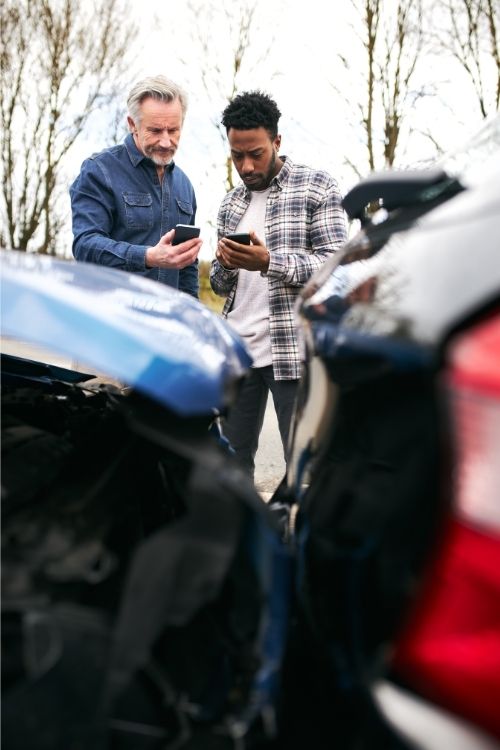 two men exchanging information after car accident